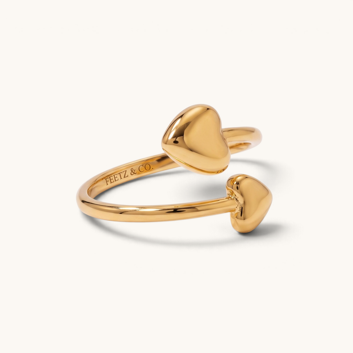 Feetz & Co. gold adjustable toe ring featuring two polished heart charms in a water-resistant stainless steel design.