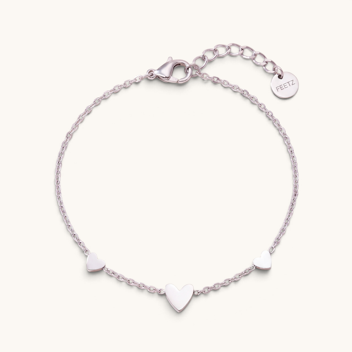 Feetz & Co. Amore silver-tone stainless steel anklet featuring three delicate heart charms on a fine cable chain.