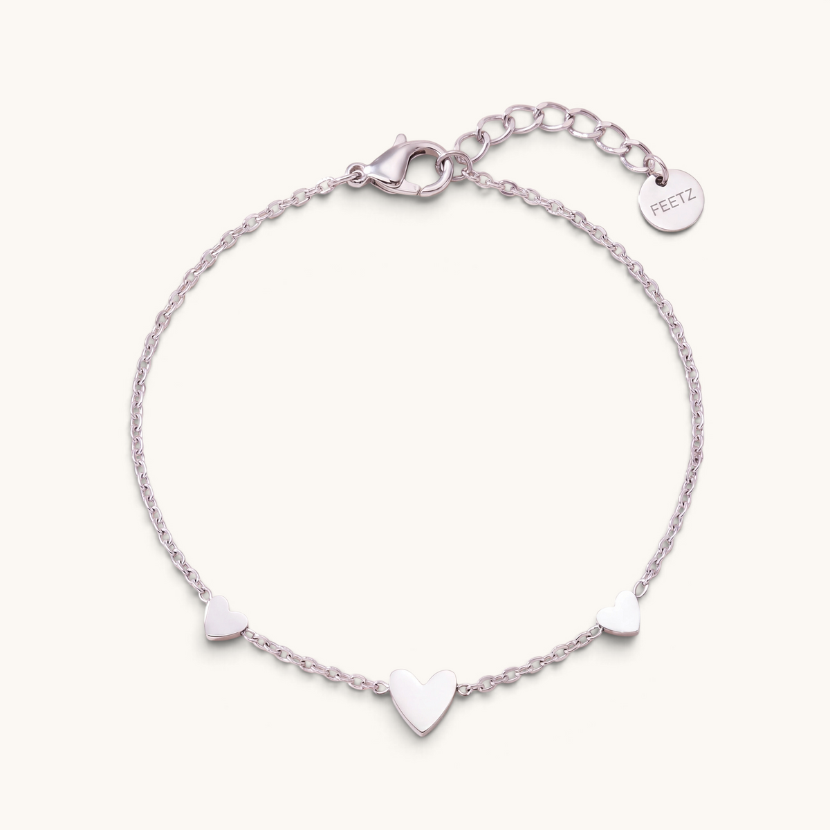 Feetz & Co. Amore silver-tone stainless steel anklet featuring three delicate heart charms on a fine cable chain.