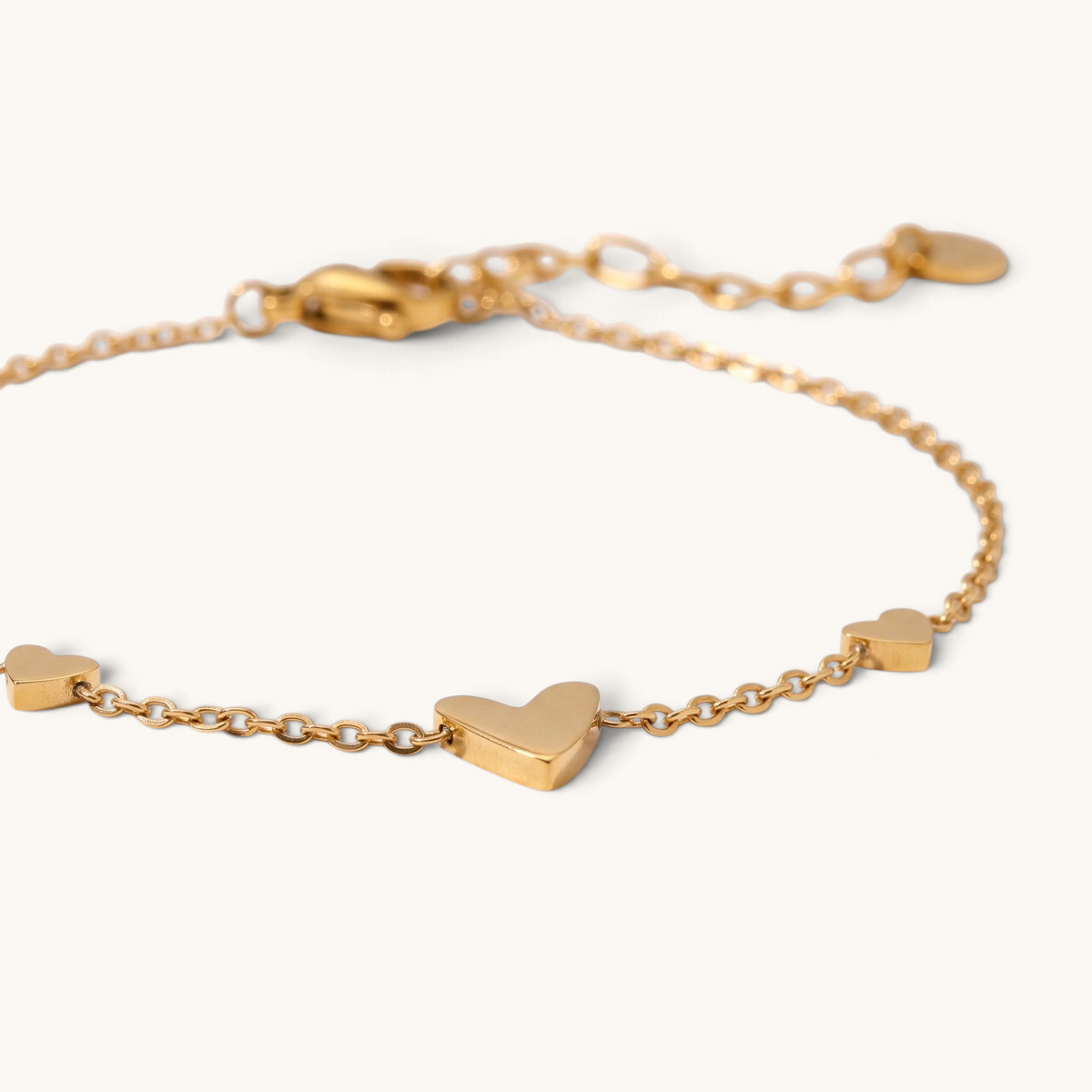 Feetz & Co. Amore gold-tone stainless steel anklet featuring three delicate heart charms on a fine cable chain.