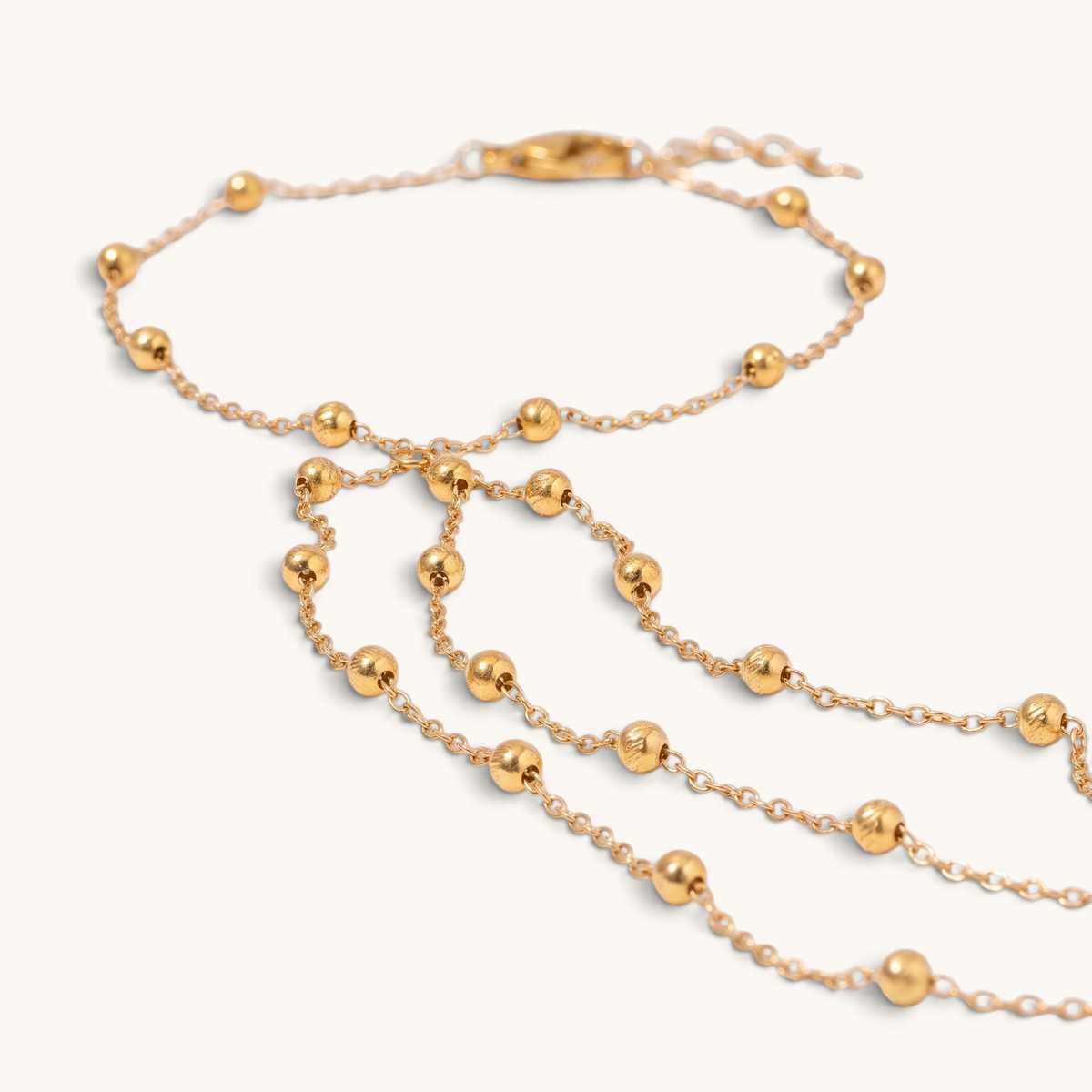 Feetz & Co. Cascade gold-plated stainless steel barefoot sandal with layered beaded chains and a toe loop.