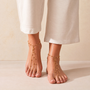 Feetz & Co. Cascade gold-plated stainless steel beaded barefoot sandals worn on a woman's feet.