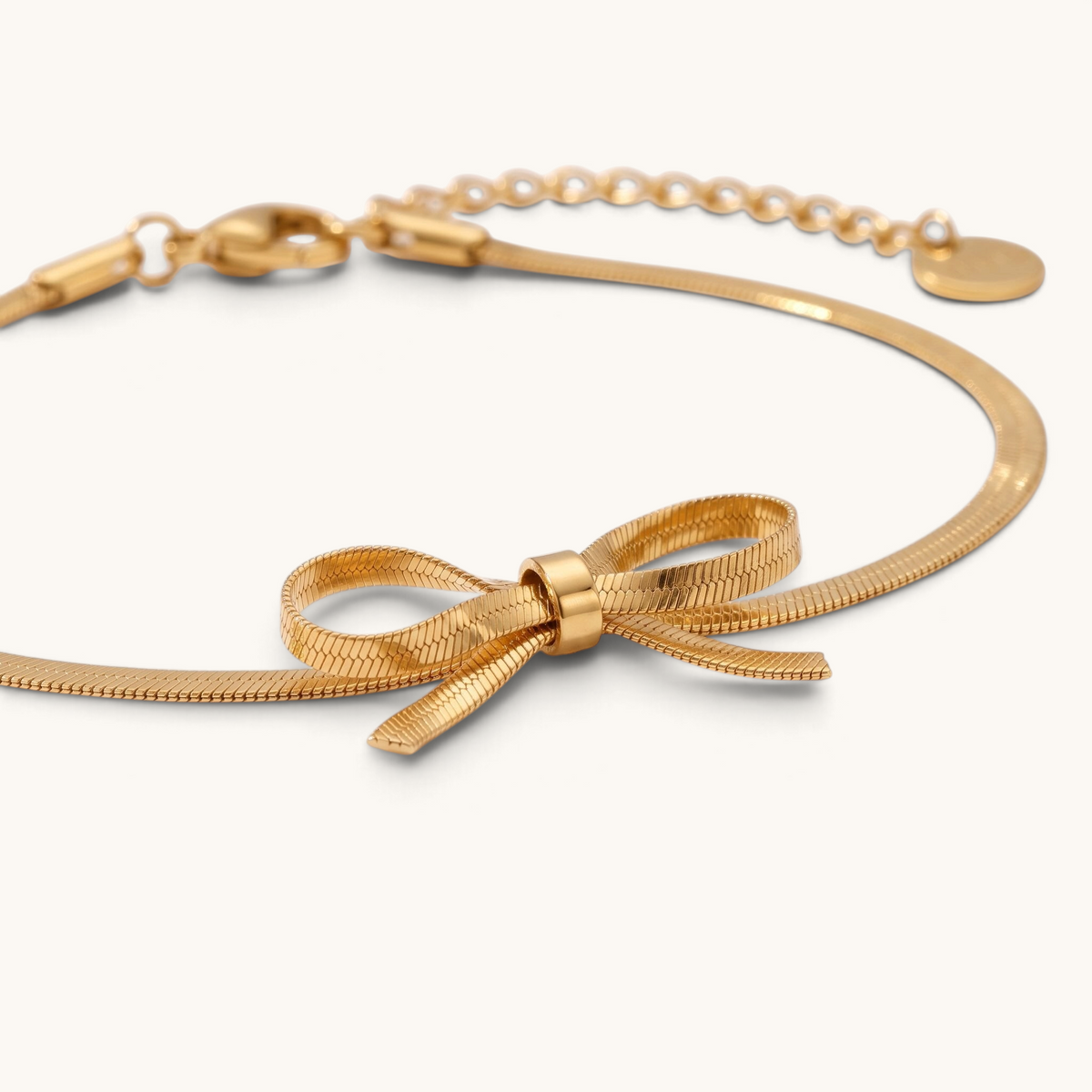 Feetz & Co. Eterna gold herringbone chain anklet featuring a delicate flat bow design in polished stainless steel.