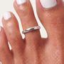 Feetz & Co. silver-plated stainless steel single toe ring with a smooth polished finish on a toe with white polish.