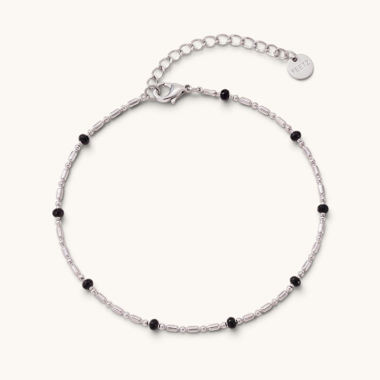 Feetz & Co. Onice anklet featuring a silver-tone stainless steel chain with small black beads and a logo charm.