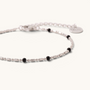 Feetz & Co. Onice anklet featuring a fine silver-tone stainless steel chain with small black beads and a logo tag.