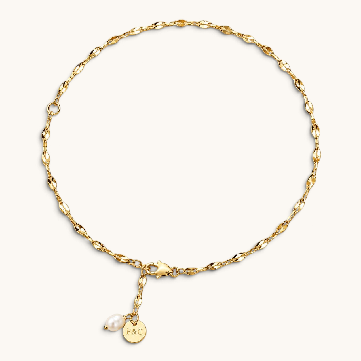 Feetz & Co. Pia anklet featuring a delicate 18K gold-plated chain with a freshwater pearl and branded charm.