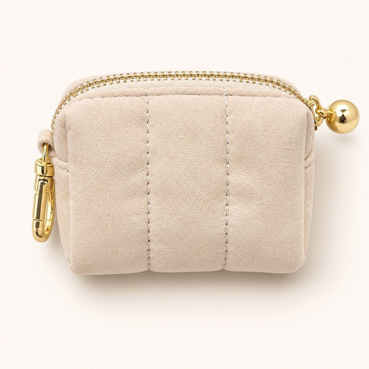 Feetz & Co. beige quilted suede-feel puffy pouch with a gold zipper and metal clip for keys or bags.