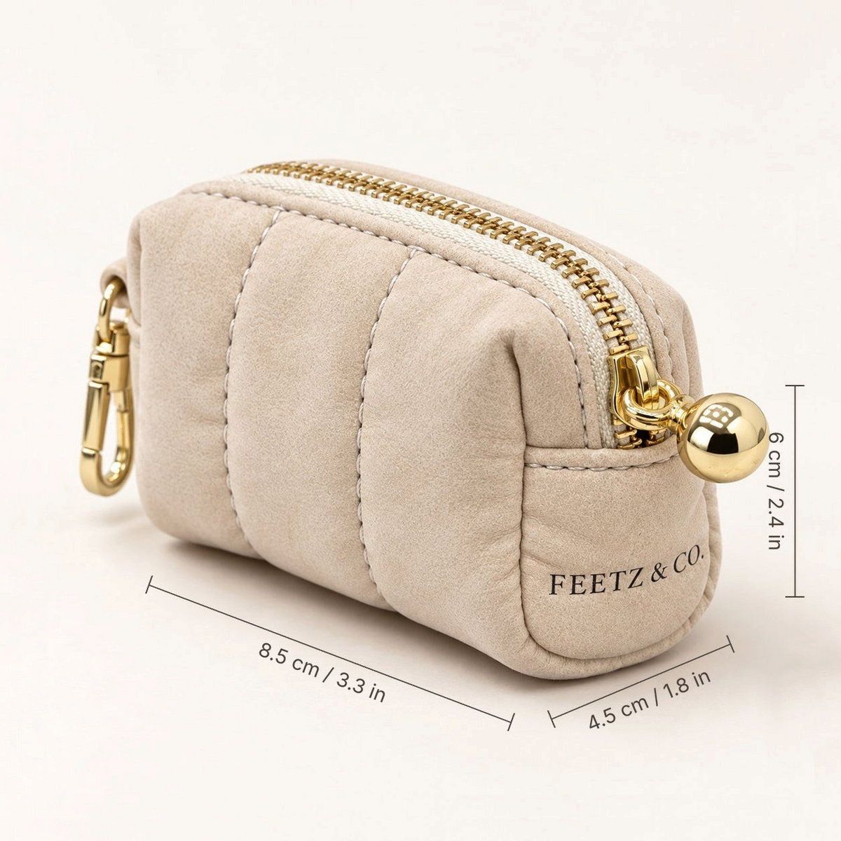 Feetz & Co. beige quilted suede-feel puffy pouch with a gold zipper and clip for keys or bags.